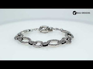 Wholesale sterling silver Bali link bracelet with alternating engraved infinity links and circular connectors, finished with a secure toggle lock for premium jewelry inventory.