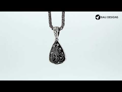 Sterling silver teardrop pendant with raised droplet motif and Bali swirl carvings, handcrafted in Bali.