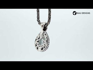 Sterling silver pendant featuring a teardrop Mystic Quartz set in a detailed carved Balinese frame with a glossy polished finish.