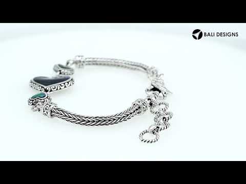 Wholesale sterling silver bracelet featuring Turquoise Shell heart motifs, crafted with intricate Balinese ornamental detailing and secured with a lobster lock for premium artisan-style jewelry collections.