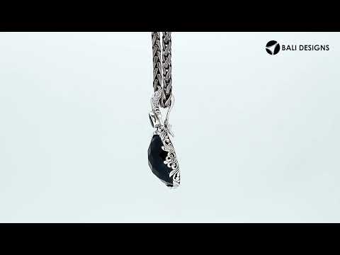 Sterling silver pendant featuring Ruby Quartz with Blue Topaz Quartz accent set in a carved Balinese frame with a polished glossy finish.