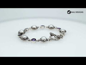 Wholesale sterling silver bracelet featuring alternating Mabe Pearl and Amethyst quartz gemstones in decorative round links with oxidized detailing and a secure toggle lock closure.