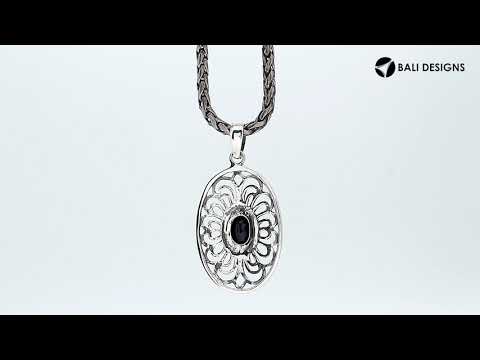 A handcrafted sterling silver pendant featuring a faceted Black Onyx in an elegant oval Balinese filigree frame.
