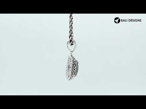 Sterling silver cushion pendant featuring a faceted London Blue Topaz Quartz centerpiece accented with ornate Balinese scroll carvings and a polished decorative frame.