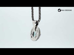 Sterling silver oval pendant featuring a vibrant Blue Topaz Quartz center decorated with intricate Balinese scroll carvings and a smooth, polished artistic frame.