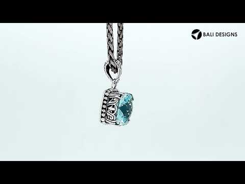 Sterling silver pendant with cushion-cut blue topaz quartz, handcrafted in Bali with ornate scrollwork and oxidized detailing.