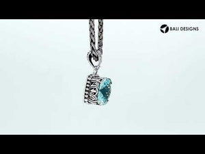 Sterling silver pendant with cushion-cut blue topaz quartz, handcrafted in Bali with ornate scrollwork and oxidized detailing.