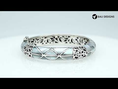 Sterling silver hinged bangle with mother of pearl inlay and intricate filigree design handcrafted in Bali.