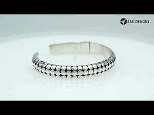Sterling silver medium bangle featuring polished dot pattern detailing, oxidized accents, and a secure hinge lock crafted for reliable and stylish wholesale jewelry selections.