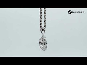 Sterling silver cushion pendant featuring a faceted Blue Topaz Quartz centerpiece accented with intricate Balinese scroll carvings and a polished decorative frame.