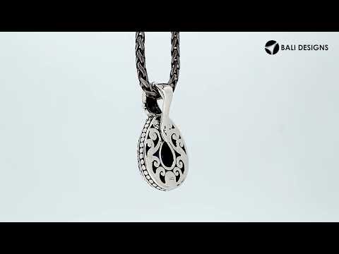 Sterling silver pendant featuring a faceted Sapphire Quartz teardrop set in a carved Balinese frame with a polished glossy finish.