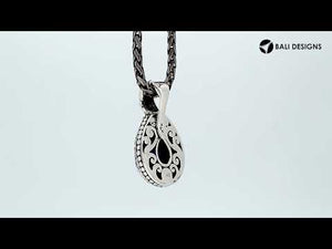 Sterling silver pendant featuring a faceted Sapphire Quartz teardrop set in a carved Balinese frame with a polished glossy finish.