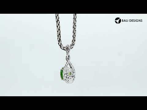 Sterling silver twisted loop pendant featuring a round Peridot Quartz centerpiece with carved Balinese engraving and polished artistic round design.
