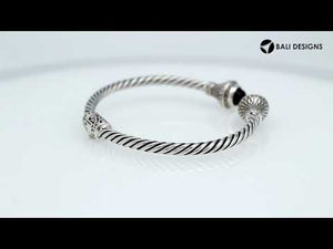 Sterling silver twisted cuff bracelet with Black Onyx caps and detailed oxidized Balinese motifs.