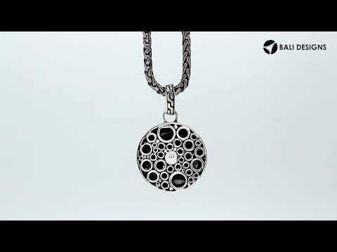 Sterling silver round skull pendant with carved texture and polished detailing.