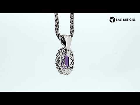 Sterling silver oval pendant featuring faceted Ruby Quartz and detailed Balinese floral engraving.