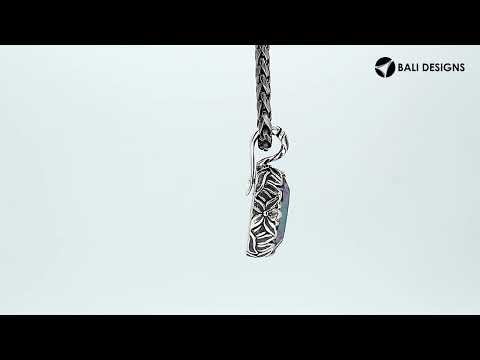 Sterling silver oval-shaped Mystic Quartz pendant with intricate floral detailing and enhancer bail, featuring iridescent hues and polished shine, ideal for wholesale jewelry distributors.