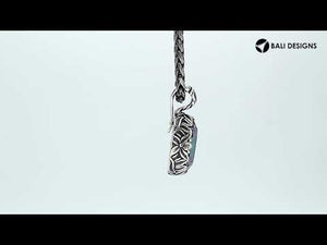 Sterling silver oval-shaped Mystic Quartz pendant with intricate floral detailing and enhancer bail, featuring iridescent hues and polished shine, ideal for wholesale jewelry distributors.