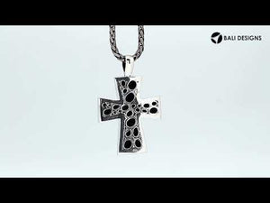 Sterling silver cross pendant featuring polished pebble texture and oxidized Balinese handcrafted detailing.