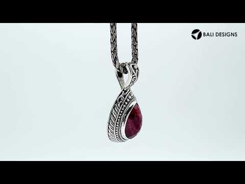 Sterling silver teardrop pendant featuring faceted Ruby Quartz set in a carved Balinese frame with a polished glossy finish.