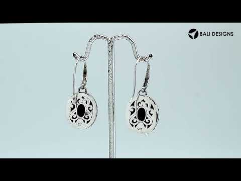 Wholesale sterling silver earrings featuring a faceted oval Sapphire stone framed with intricate carved detailing and earwire lock, offering deep blue brilliance and artisan craftsmanship ideal for premium wholesale jewelry catalogs.