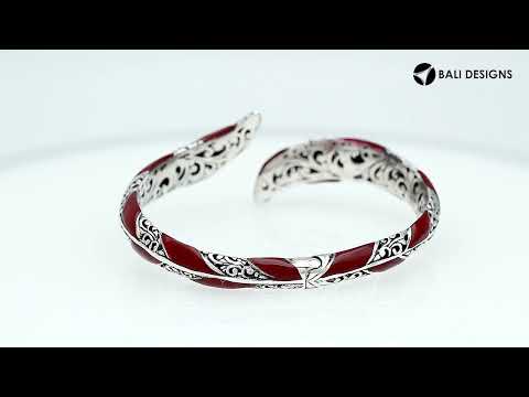 Wholesale sterling silver feather-inspired bangle featuring bold Red Coral inlays, ornate Balinese scroll engravings, and a secure hinge lock for premium artisan-style jewelry assortments.