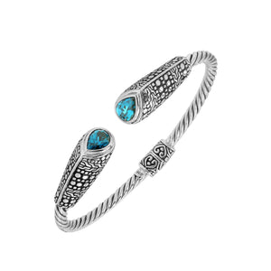 Sterling silver twisted bangle with blue topaz quartz ends and Balinese oxidized dot pattern