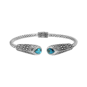 Sterling silver twisted bangle with blue topaz quartz ends and Balinese oxidized dot pattern