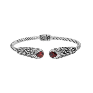 Sterling silver twisted bangle with garnet quartz ends and Balinese oxidized dot pattern