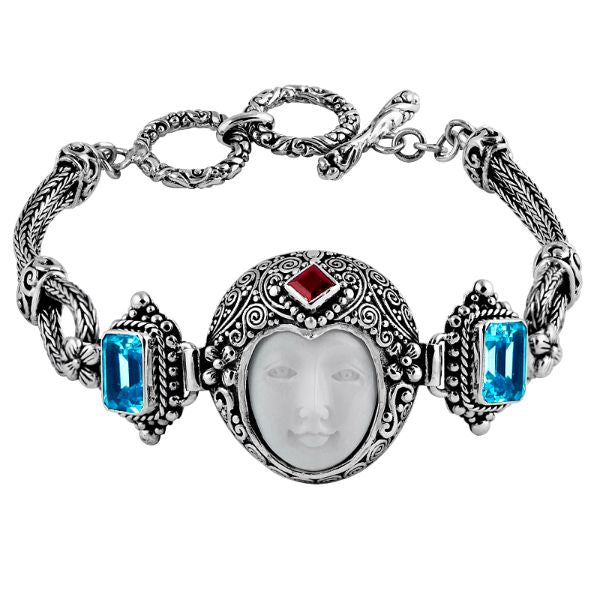 Sterling Silver bracelet featuring a carved bone face centerpiece, Red Garnet Quartz and Blue Topaz Quartz accents, ornate scrollwork, and a secure toggle lock for wholesale collections.