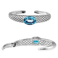 A handcrafted sterling silver cuff bracelet featuring a centered Blue Topaz Quartz with detailed scale-texturing and a secure hinge-lock made for dependable wholesale catalog use.