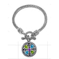 A handcrafted sterling silver bracelet featuring a woven chain, multi-stone pendant with Amethyst Quartz, Blue Topaz Quartz, Peridot Quartz, and a secure toggle lock ideal for wholesale presentation.