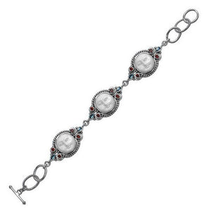 Sterling silver bracelet featuring carved bone faces with Garnet Quartz and Blue Topaz Quartz accents and an artisan toggle lock.