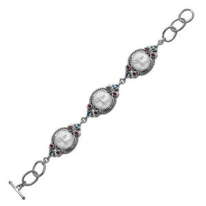 Sterling silver bracelet featuring carved bone faces with Garnet Quartz and Blue Topaz Quartz accents and an artisan toggle lock.