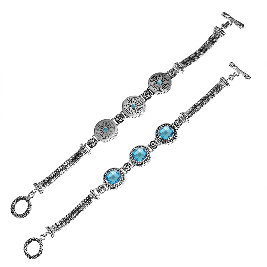 Handcrafted sterling silver bracelet with faceted Blue Topaz Quartz, circular artisan motifs, braided chain detailing, and a toggle lock.