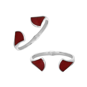 Wholesale sterling silver cuff featuring sculpted ends with bold Red Coral inlays, polished finishing, and a secure hinge lock for catalog-ready bulk presentation.