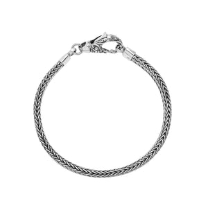 A beautifully crafted sterling silver woven bracelet with a secure lobster clasp, featuring intricate chain detailing and a mirror-polished high-gloss finish for elegant collections.