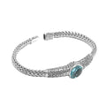 Wholesale sterling silver woven chain bracelet featuring a brilliant Blue Topaz Quartz centerpiece, Balinese leaf engravings, and a secure push clasp for premium gemstone-focused assortments.