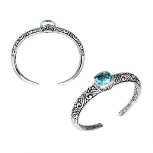 Wholesale sterling silver open bangle with a cushion-cut Blue Topaz Quartz centerpiece, intricate Balinese scroll engravings, and a secure hinge lock for artisan jewelry assortments.