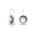 Wholesale sterling silver Bali granulated earrings featuring luminous mabe pearl centers with polished–oxidized detailing, crafted to enhance luxury artisan-focused wholesale jewelry collections.