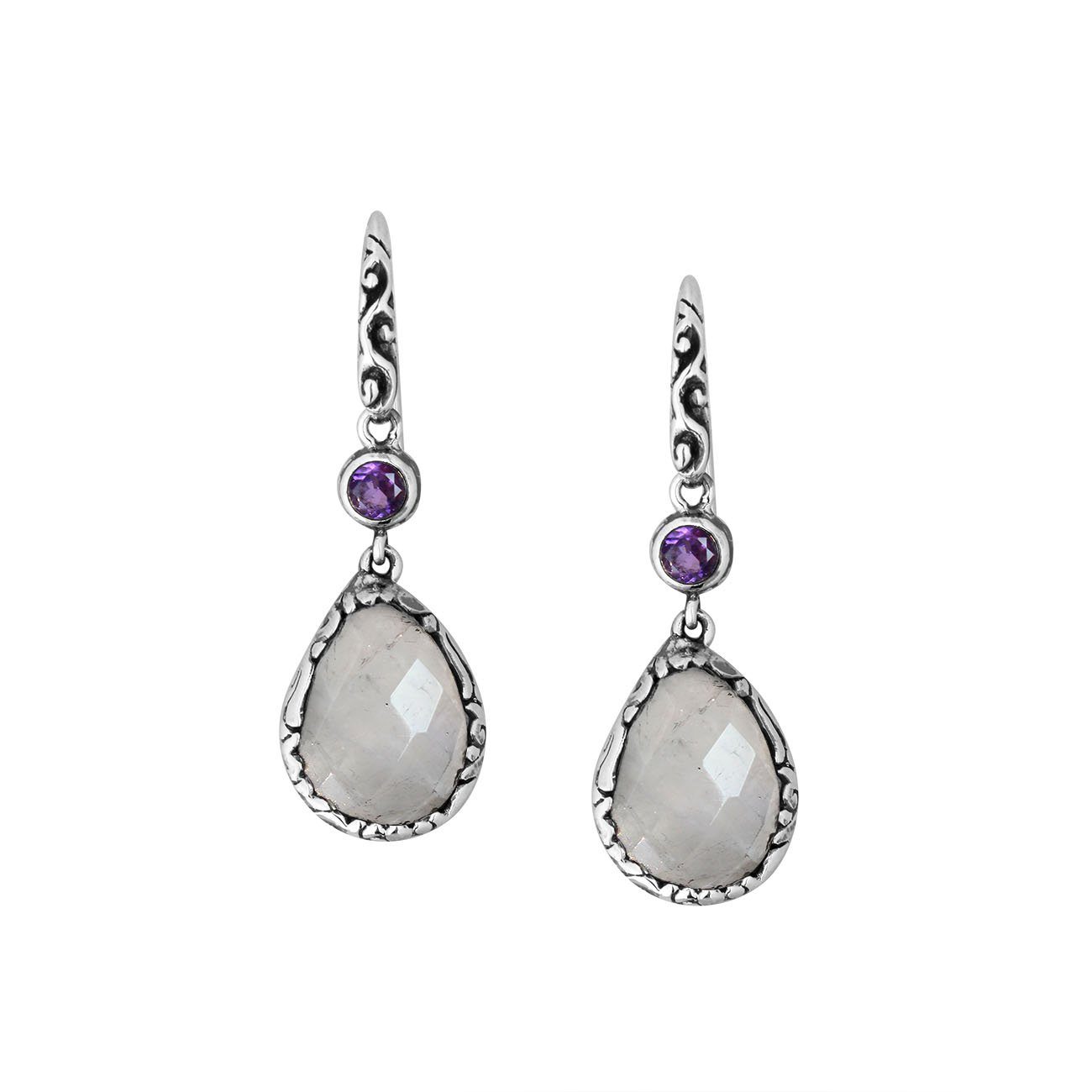Wholesale sterling silver earrings combining a faceted rainbow moonstone teardrop with an amethyst quartz accent, framed by ornate Balinese detailing for consistent artisan quality and strong catalog-ready wholesale presentation.