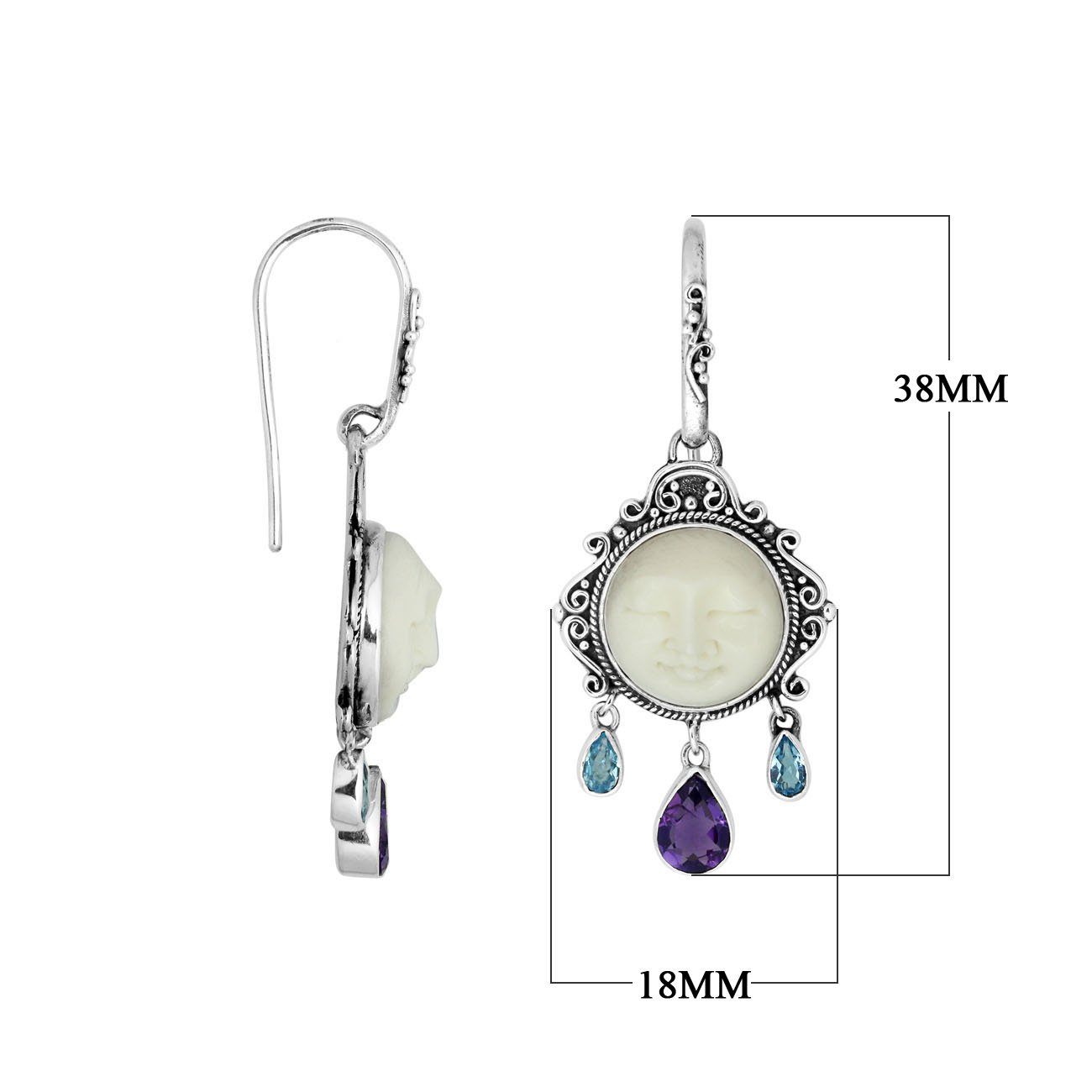 Wholesale sterling silver earrings featuring a carved bone face framed by ornate Balinese detailing, accented with blue topaz quartz and an amethyst quartz drop for consistent artisan-quality presentation.