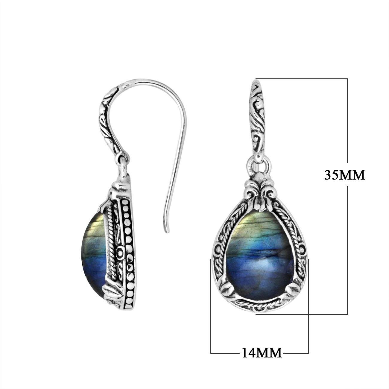Wholesale sterling silver earrings featuring a luminous Labradorite teardrop with shifting blue and gold tones, framed in deeply carved borders and finished with an earwire lock for premium artisan wholesale collections.