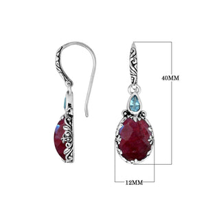 Wholesale sterling silver earrings featuring a deep Ruby Quartz drop complemented by a bright Blue Topaz Quartz accent with ornate carved borders for premium catalog presentation.