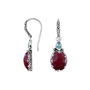 Wholesale sterling silver earrings featuring a deep Ruby Quartz drop complemented by a bright Blue Topaz Quartz accent with ornate carved borders for premium catalog presentation.