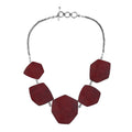 Sterling silver necklace with hexagon-shaped red coral links, polished artisan finish.