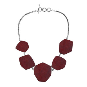 Sterling silver necklace with hexagon-shaped red coral links, polished artisan finish.