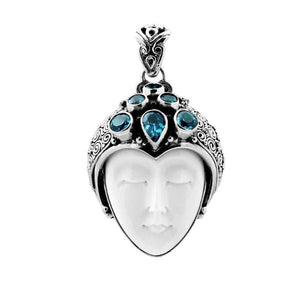 Wholesale sterling silver pendant with hand-carved bone goddess face and faceted blue topaz gemstones, handcrafted Balinese artisan jewelry design.