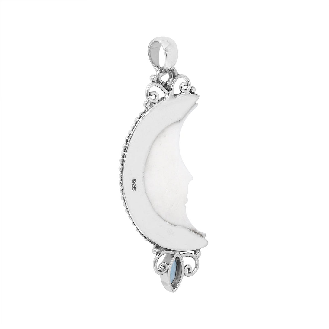 Sterling silver crescent moon pendant with carved bone face and marquise blue topaz gemstone, Balinese artisan jewelry.
