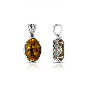 Sterling silver pendant with oval-cut citrine quartz, handcrafted in Bali with scroll carvings and oxidized finish.